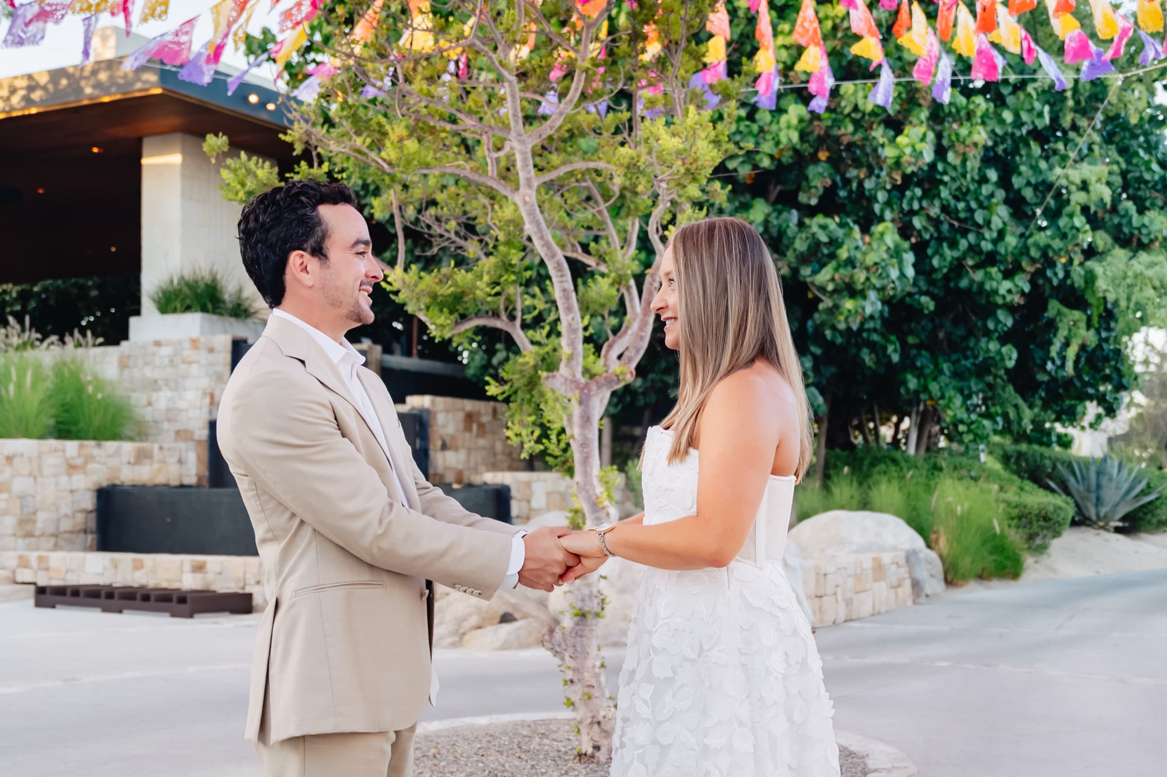 Laughing and holding hands under colorful banners