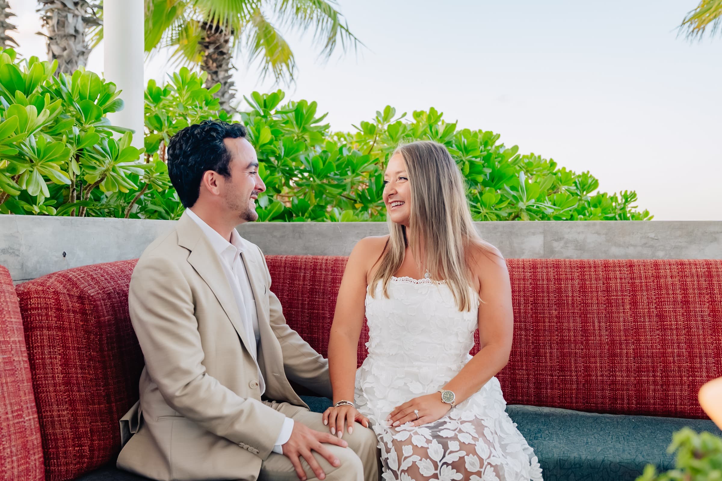 Sitting together on a tropical resort lounge with palms