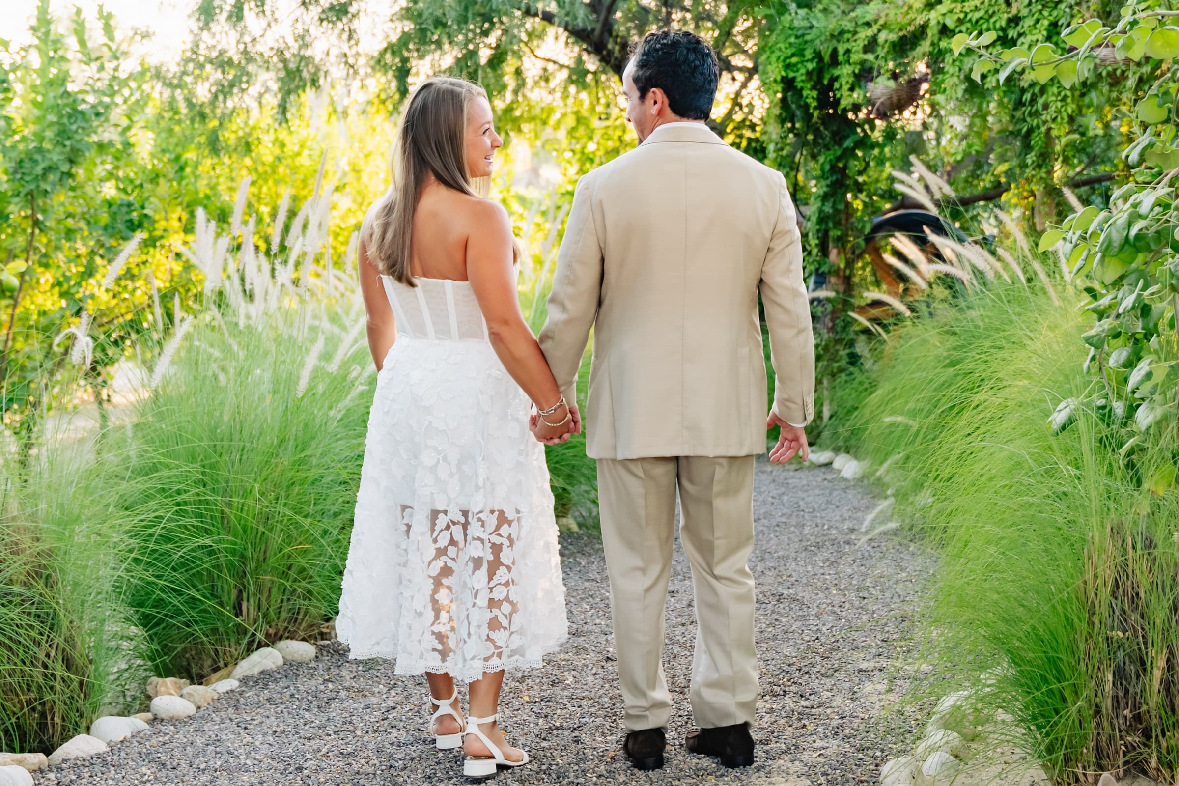 Strolling hand in hand along a garden path from behind