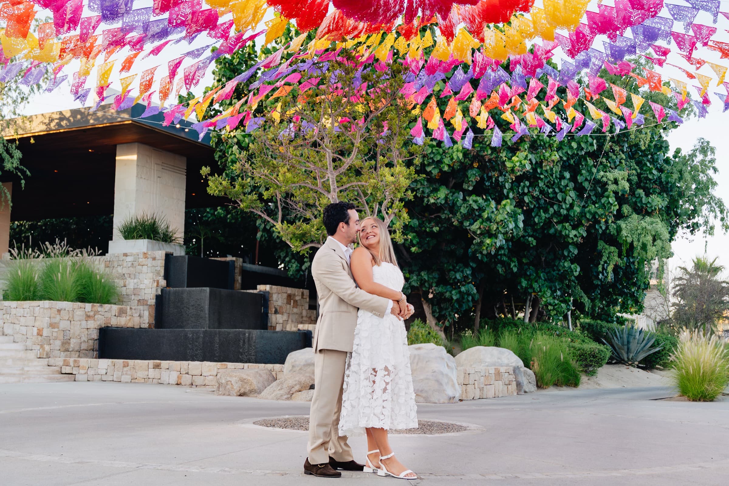 Kiss under colorful papel picado banners in Mexico