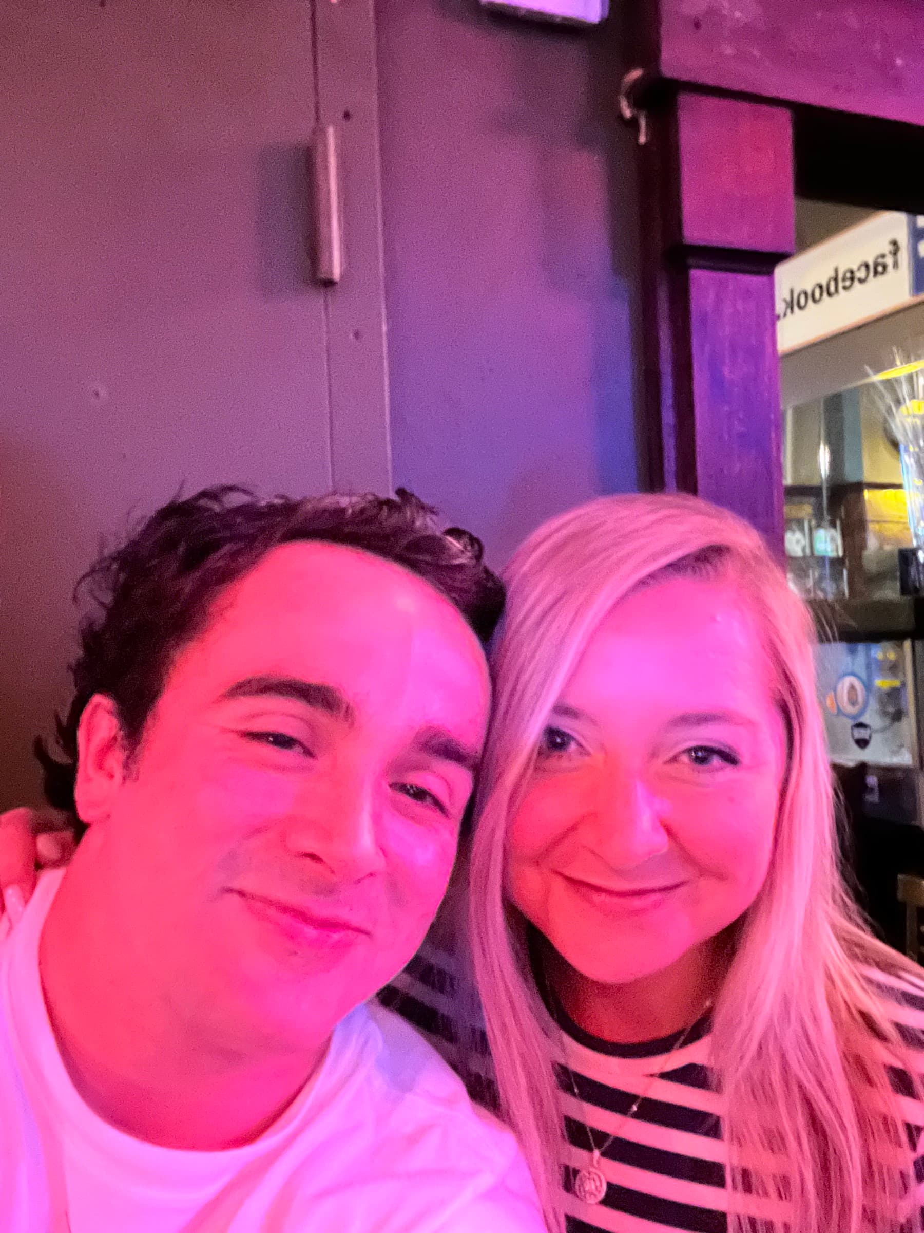 Selfie together under pink and purple club lights
