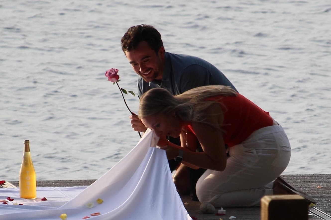 Taylor overcome with joy holding a rose after the proposal