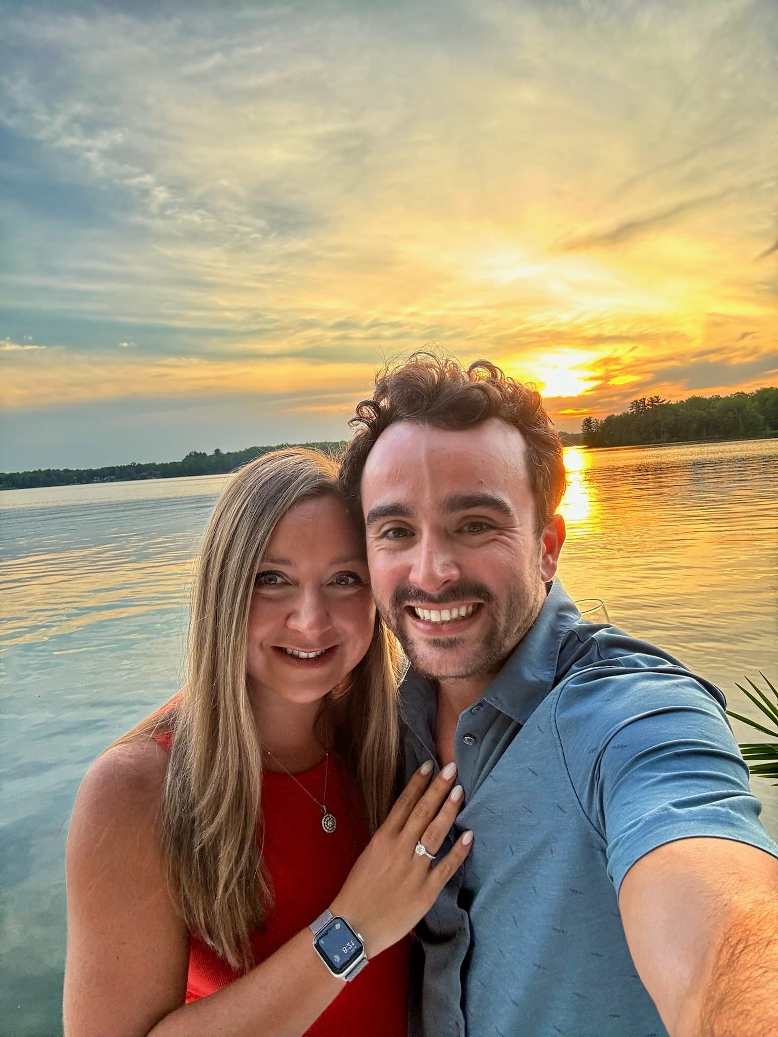 Newly engaged selfie with a golden lake sunset behind