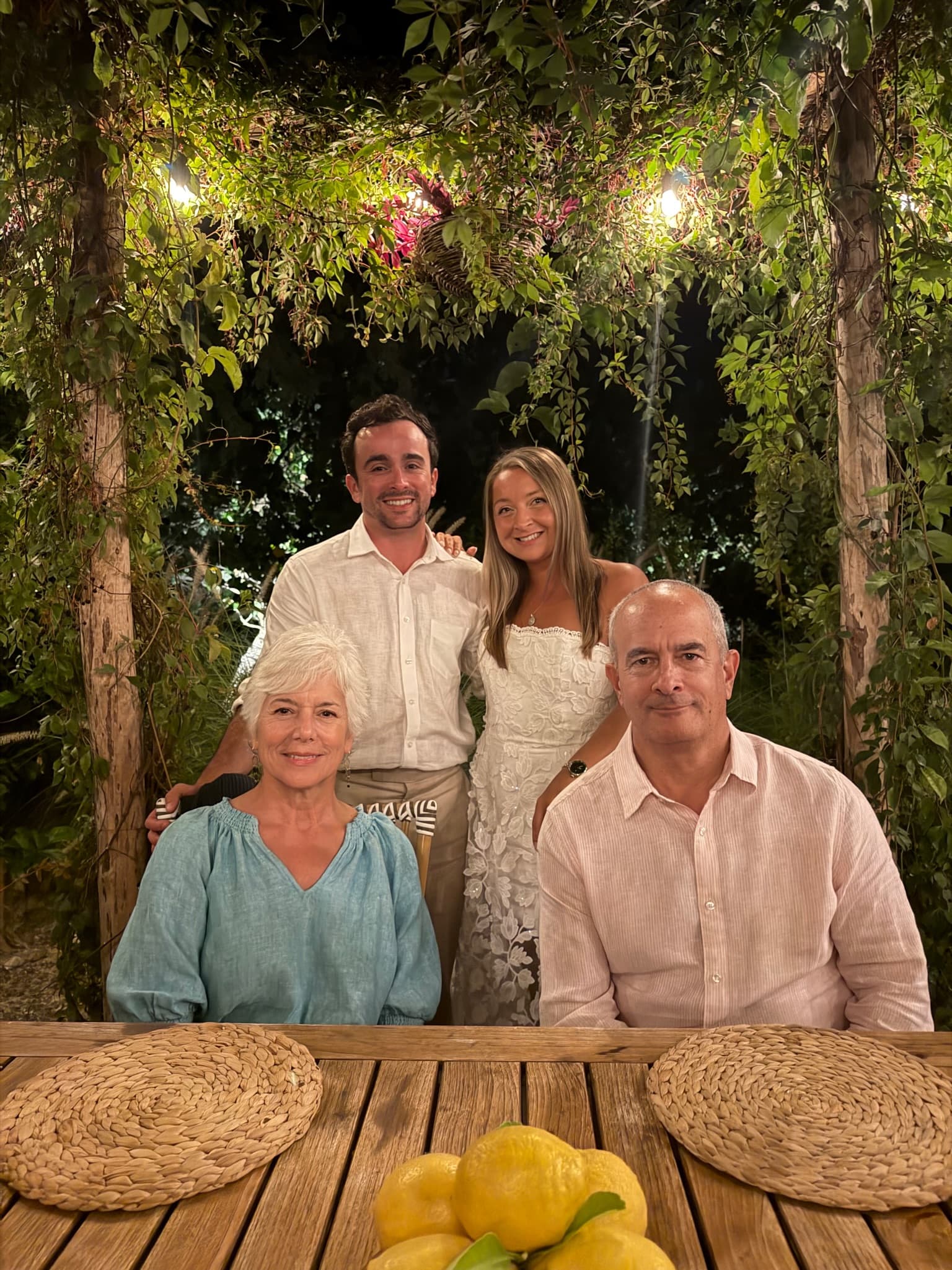 With family under a vine-covered pergola with lemons