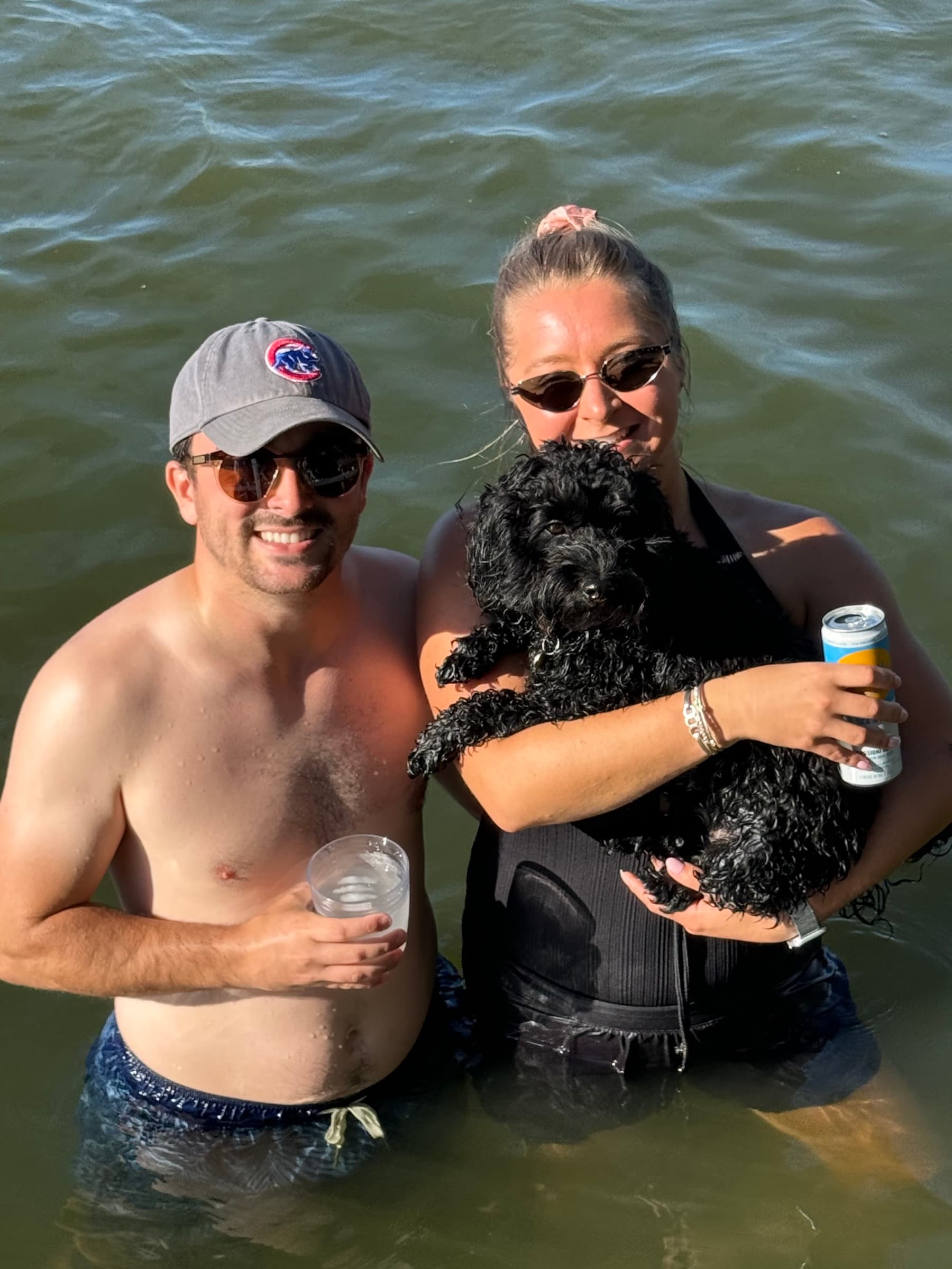 Wading in the lake with their dog on a sunny day