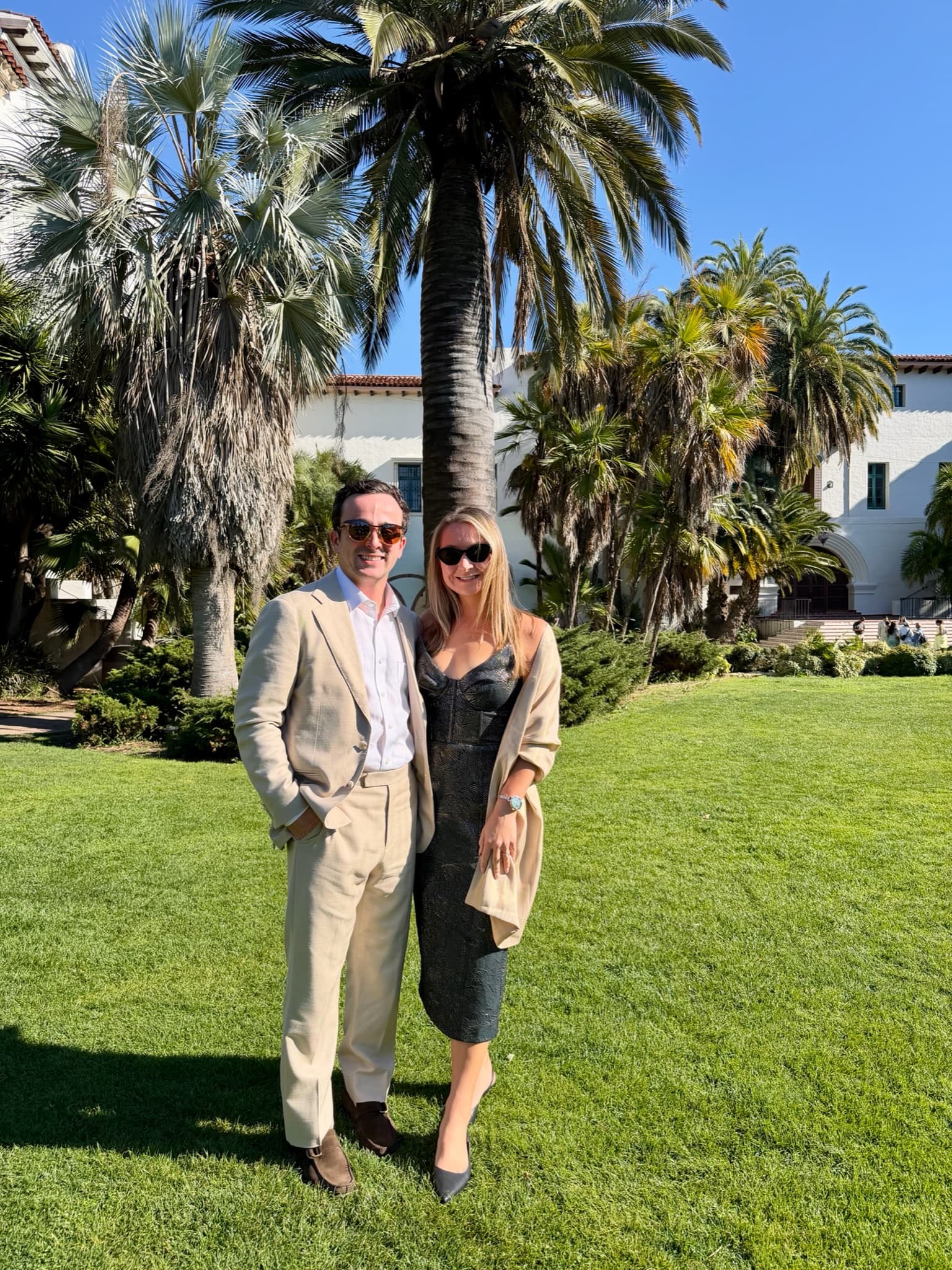 Dressed up under palm trees on a sunny lawn