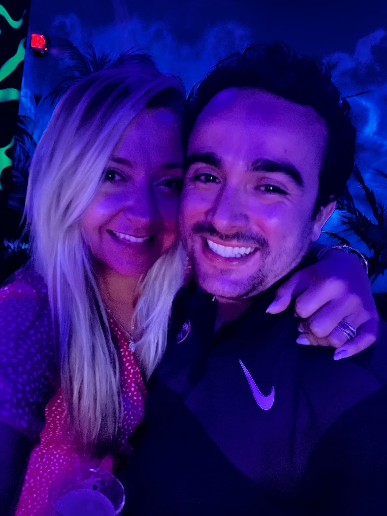 Close-up selfie together under purple neon lights
