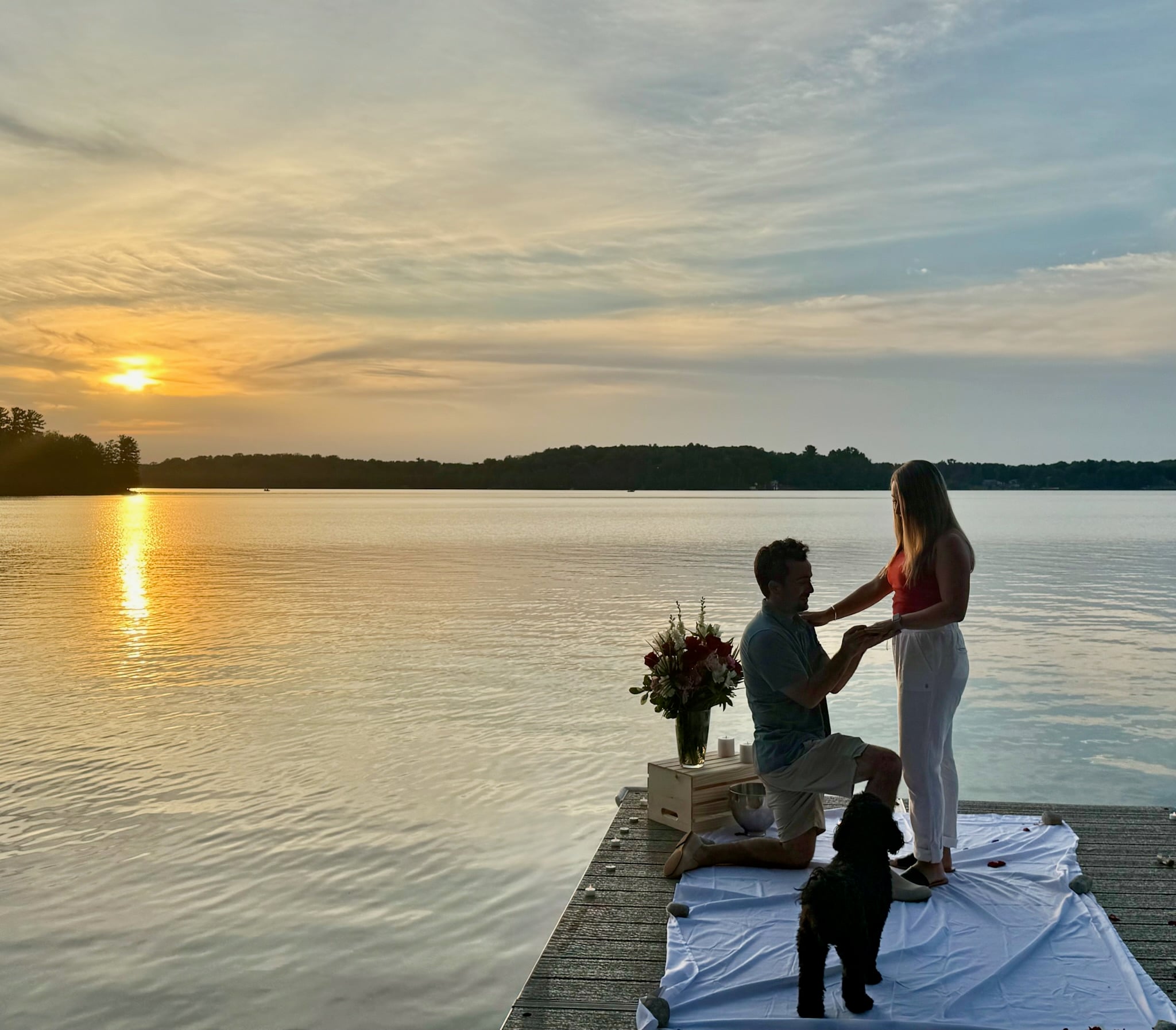 Jeffrey proposing to Taylor on a dock at sunset with Larry